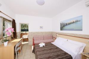 Camera piccola con letto, tavolo e scrivania. di Albergo Torrente a Vieste