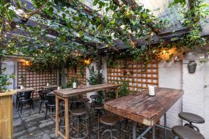 an outdoor patio with tables and chairs and plants at The Wolfpack Inn in London