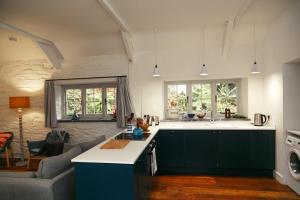 a kitchen and living room with a couch at The Cottage at Noyadd Trefawr - Grade II* in Cardigan