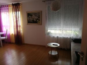 a living room with a couch and a table and a window at Iver apartman in Sesvete