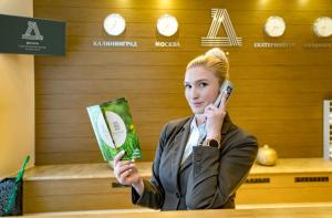 a woman talking on a cell phone in a store at Health Resort Desna in Voskresenskoye