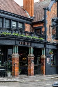 um edifício com um restaurante com plantas na frente em The Wolfpack Inn em Londres