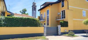 un edificio amarillo con una torre de reloj en el fondo en Villa Jasmine B&B, en Gattico