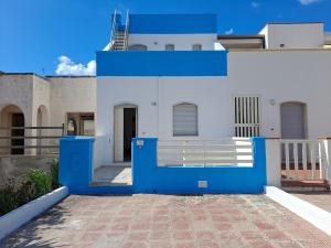 una casa azul y blanca con una puerta azul en Casa Luigi a 400m Dalla Sabbia en Lido Marini