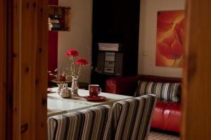 PommerbyにあるFerienwohnung Muehlenblickのテーブルと赤いソファのあるリビングルーム