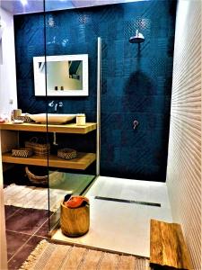 a bathroom with a shower with a blue wall at Villa Dionysos in Plaka