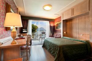 een hotelkamer met een bed, een bureau en een raam bij Grand Hotel Dino in Baveno +37 foto's