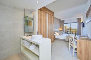 een badkamer met een wastafel en een slaapkamer met een bed bij Hotel Playa Golf in Playa de Palma