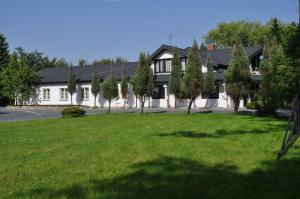 ein Haus mit grünem Rasen davor in der Unterkunft Pokoje Zimna Woda in Rozalin