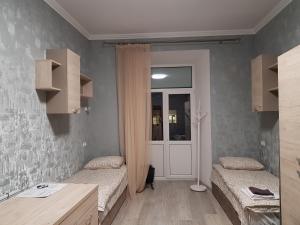a small room with two beds and a door at Hostel "Гном & Gnome" in Lviv