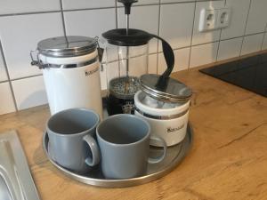 a tray with three cups on a kitchen counter at Ferienwohnung Keilbergblick in Kurort Oberwiesenthal