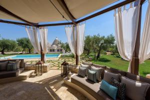 an outdoor patio with couches and a pool at Trullo Atena in Alberobello