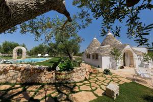 an external view of a house with a stone wall at Trullo Atena in Alberobello