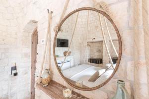 a large mirror in a room with a swing at Trullo Atena in Alberobello +14 photos