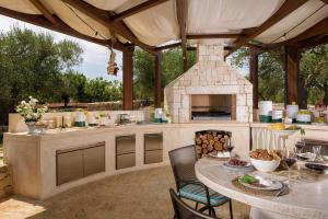 an outdoor kitchen with a table and a stone oven at Trullo Atena in Alberobello