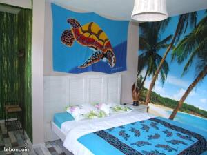 a bedroom with a bed with a fish painting on the wall at Le Clos du Chêne in Langon