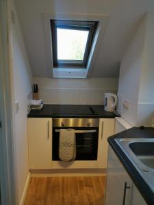 a small kitchen with a stove and a window at Unique Studio III with free WIFI in Maidstone