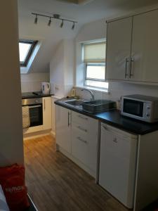 a kitchen with a sink and a microwave at Unique Studio III with free WIFI in Maidstone