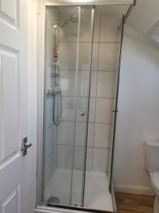 a shower with a glass door in a bathroom at Unique Studio III with free WIFI in Maidstone