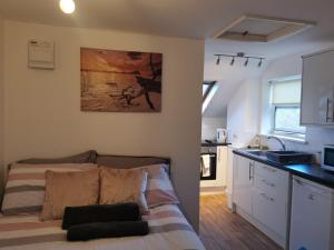 a small bedroom with a bed and a kitchen at Unique Studio III with free WIFI in Maidstone