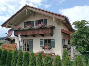 a house with a balcony with flowers on it at Ferienwohnung Heimat | Chiemgau Karte in Grassau
