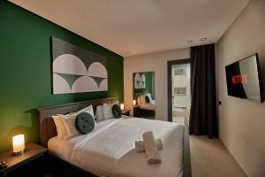 1 dormitorio con 1 cama con pared verde en Stayhere Rabat - Agdal 3 - Prestige Residence, en Rabat