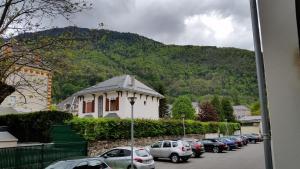 a parking lot with cars parked in front of a mountain at LES JARDINS DE RAMEL in Luchon