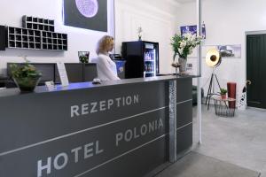 Una donna è in piedi alla reception di un hotel di Hotel Polonia - Frankfurt/Oder a Francoforte sull'Oder
