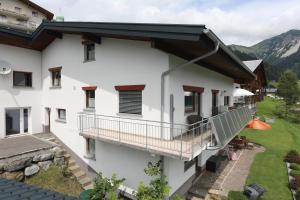 Casa blanca con balcón con mesa en Haus Resi en Fontanella
