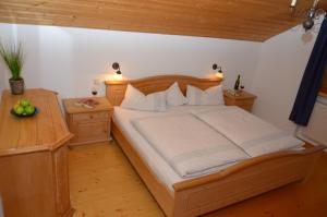 1 dormitorio con cama de madera y mesa de madera en Ferienwohnung Haus Wuhrbichl, en Marquartstein