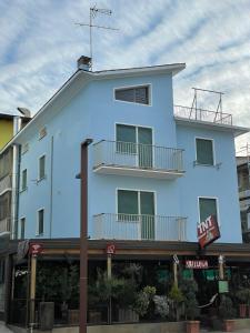 un edificio blu con un balcone sopra di Giovanna Rooms a Caorle