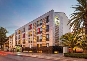 un edificio con un reloj al costado. en B&B HOTEL Málaga Centro en Málaga