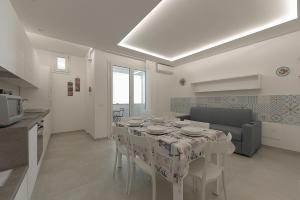 a kitchen and a dining room with a table and chairs at Isule Apartments in San Vito lo Capo