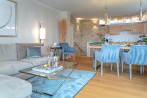 a living room and kitchen with a couch and a table at Ferienwohnung Luxus mit Wattenmeerblick in Morsum