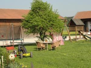 un cortile con tavolo, sedie e un albero di Wagner-Schneider-Hof a Chieming