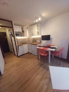 um quarto com uma cozinha, uma mesa e cadeiras em Les écureuils du Méale em Les Orres