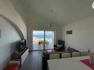 a living room with a couch and a tv at Apartman Zoe Vrbnik in Vrbnik