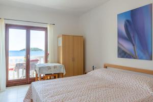 a bedroom with a bed and a view of the ocean at Apartmani Srdjana in Prizba