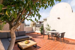 a patio with a table and chairs and a tree at Decô Apartments Barcelona-Eixample in Barcelona