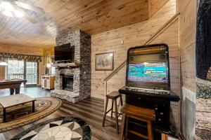 a living room with a tv and a fireplace at Mystic Falls Lodge in Waldens Creek