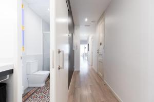 a bathroom with a toilet and a hallway at Decô Apartments Barcelona-Eixample in Barcelona +45 photos