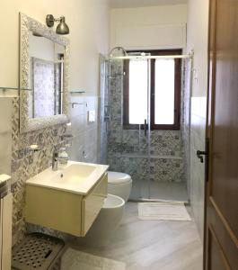 a bathroom with a sink and a toilet and a shower at Home Feeling Mascagni - Bilocale in Alghero