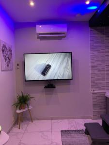 a flat screen tv on a wall in a room at Appartement spa gingko, N1 Valenciennes, Wifi, Netflix in Aulnoy