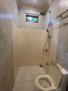 a small bathroom with a toilet and a window at Thoddoo Retreat Grand in Thoddoo