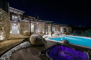 a villa with a swimming pool at night at Beyond Beachfront Super Paradise Villa in Mikonos