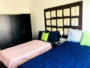 Casa Angeles في نويفو فايارتا: غرفة نوم بسريرين مع وسائد زرقاء وأخضر