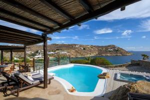 an outdoor pool with a view of the ocean at Beyond Beachfront Super Paradise Villa in Mikonos