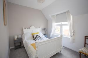 Habitación blanca con cama y ventana en Foresters Cottage, en Worthing