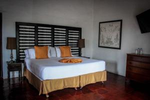 um quarto com uma grande cama branca com almofadas laranja em Hotel Casa Colonial - Adults Only em Cuernavaca