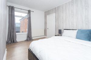 a white bedroom with a large bed and a window at The White & Warm, Free Parking & Wifi, 8 beds in Colchester